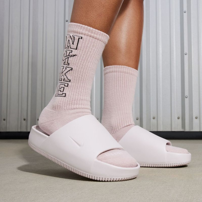 Sandalias-nike-para-mujer-W-Nike-Calm-Slide-para-natacion-color-rosado.-Vista-Lateral-Sobre-Modelo
