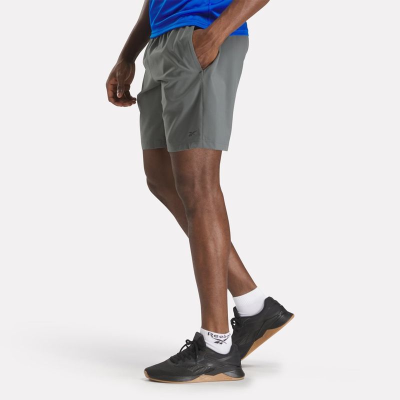 Pantaloneta-reebok-para-hombre-Wor-Woven-Short-para-entrenamiento-color-gris.-Reverso-Sobre-Modelo