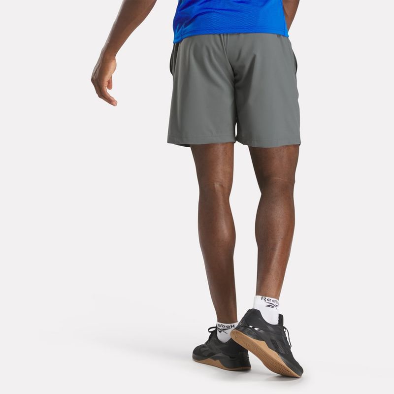 Pantaloneta-reebok-para-hombre-Wor-Woven-Short-para-entrenamiento-color-gris.-Reverso-Sobre-Modelo