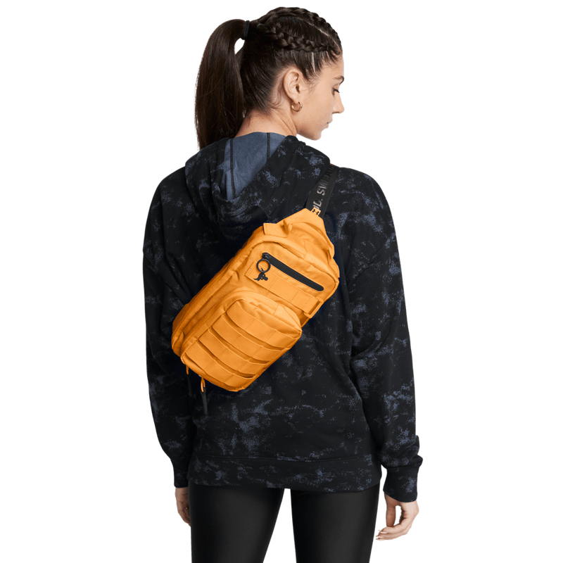 Canguro-under-armour-para-hombre-Ua-Project-Rock-Waist-Bag-para-entrenamiento-color-naranja.-Frente-Sobre-Modelo